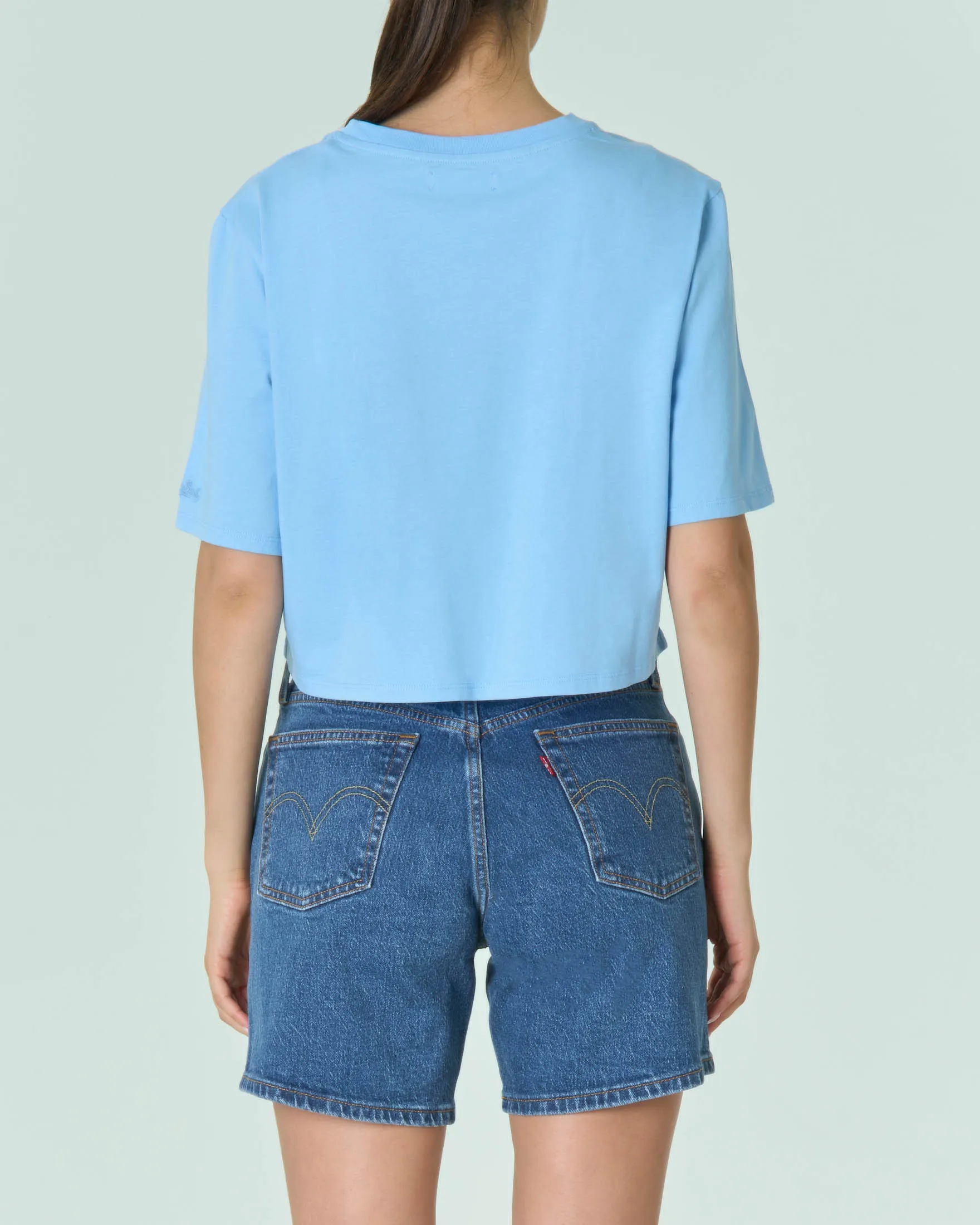 T-shirt cropped azzurra in cotone con stampa Angels Fiorucci sul davanti e maniche corte